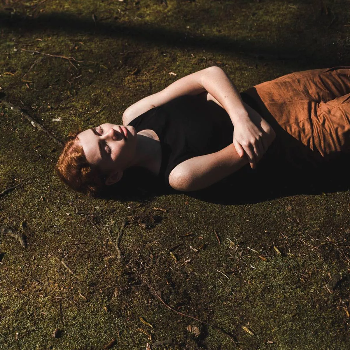 Nichtstun: eine Frau liegt auf dem Boden in der Sonne.