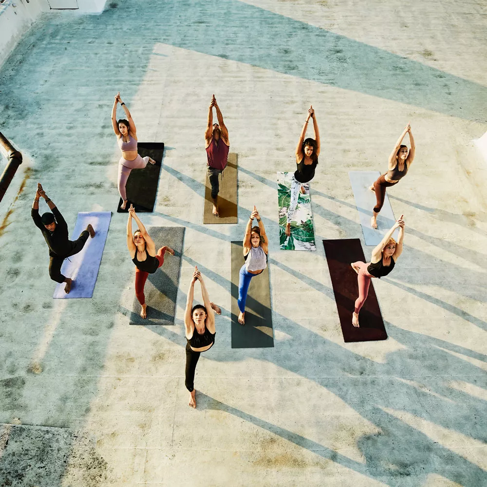 Eine Gruppe übt Power Yoga auf einer Dachterrasse.