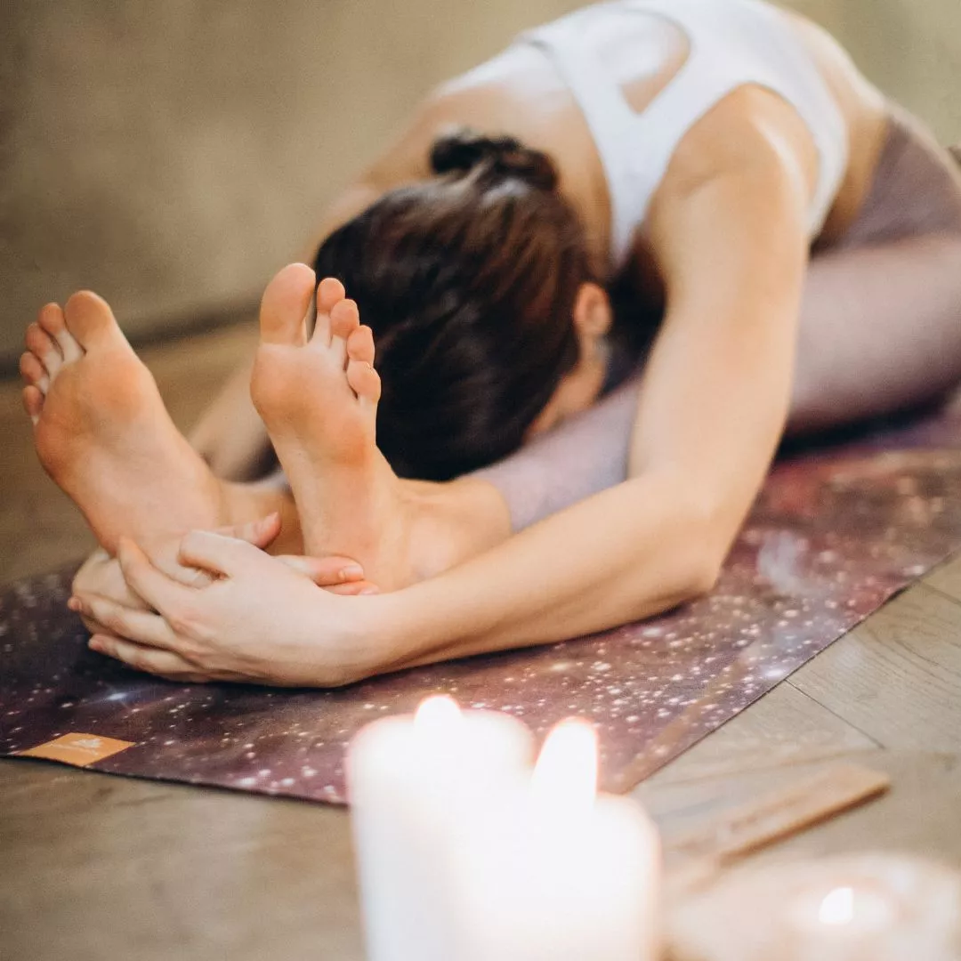 Yoga Stretching: Frau macht Vorwärtsbeuge im Sitzen