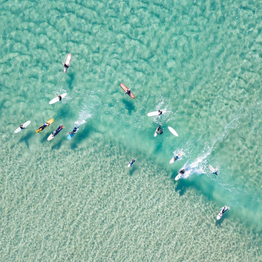 Gruppe von Surfer:innen auf dem Wasser.