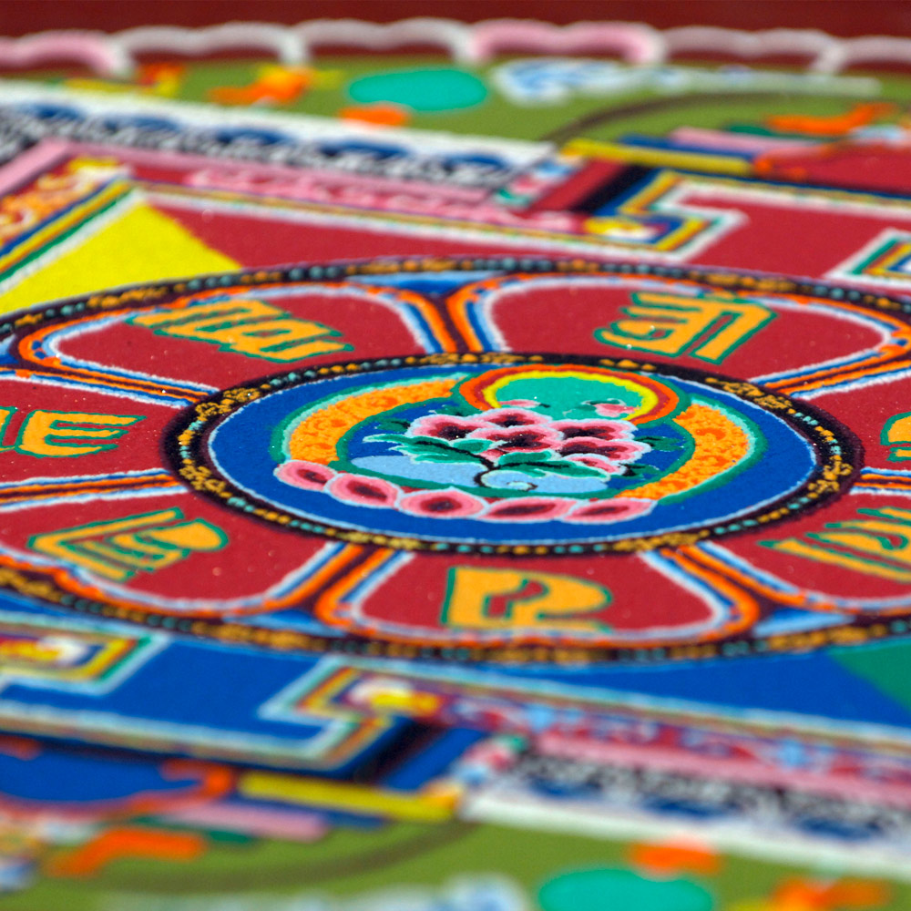 Ein tibetisches Mandala aus buntem Sand.