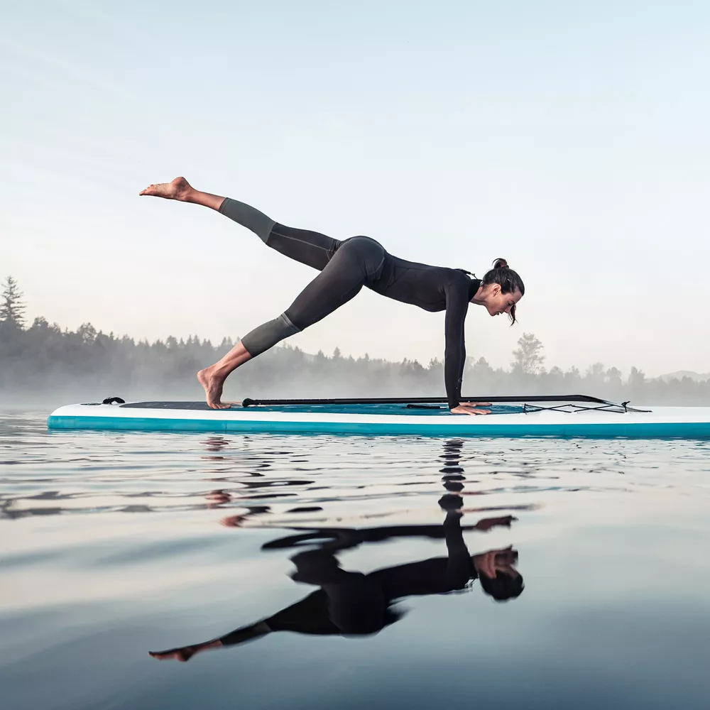 SUP Yoga: Frau macht Yoga auf einem SUP Board