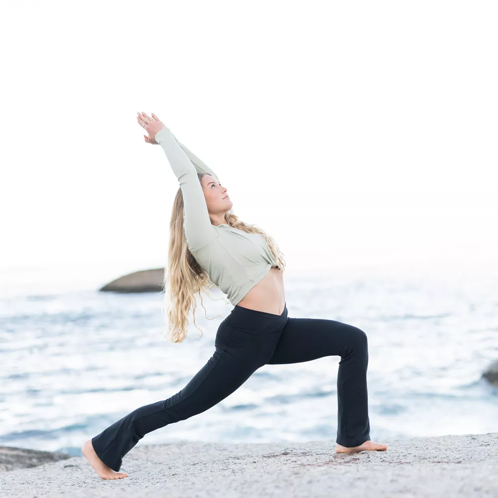 Yoga-Übungen: Frau ist im Krieger 1 mit gehobener Ferse und Rückbeuge