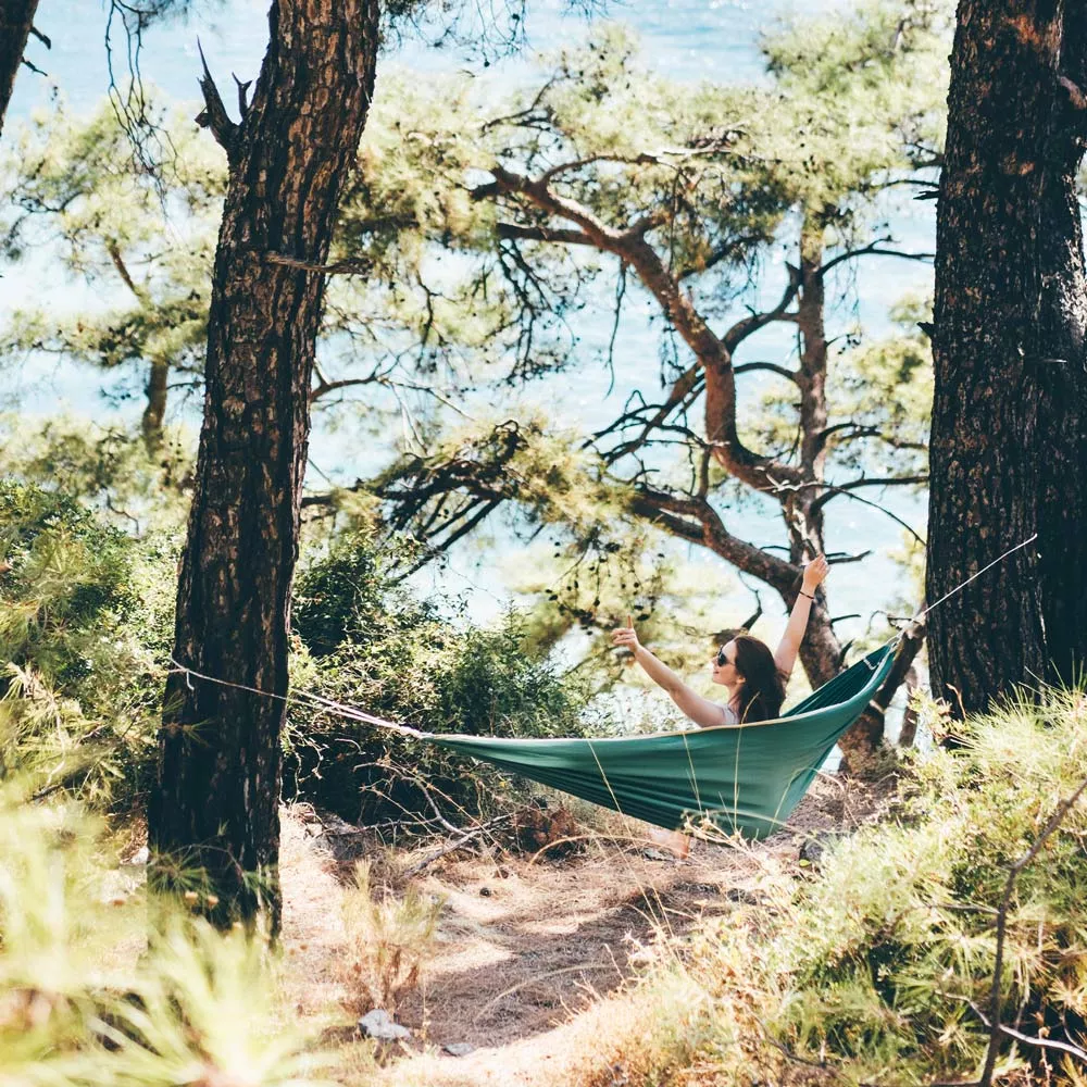 Eine Frau in einer Hängematte im Wald.