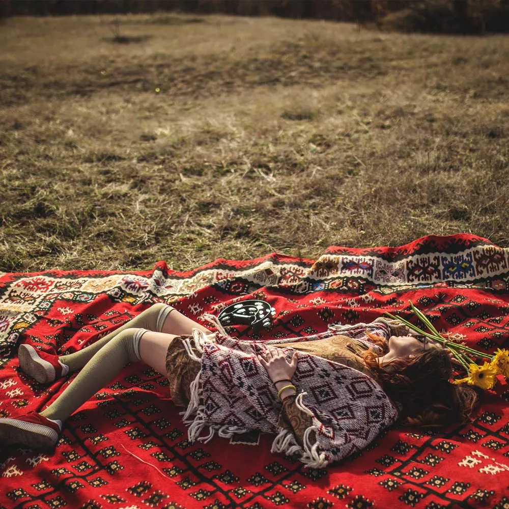 Lagom: Eine Frau liegt auf einer Decke auf der Wiese.