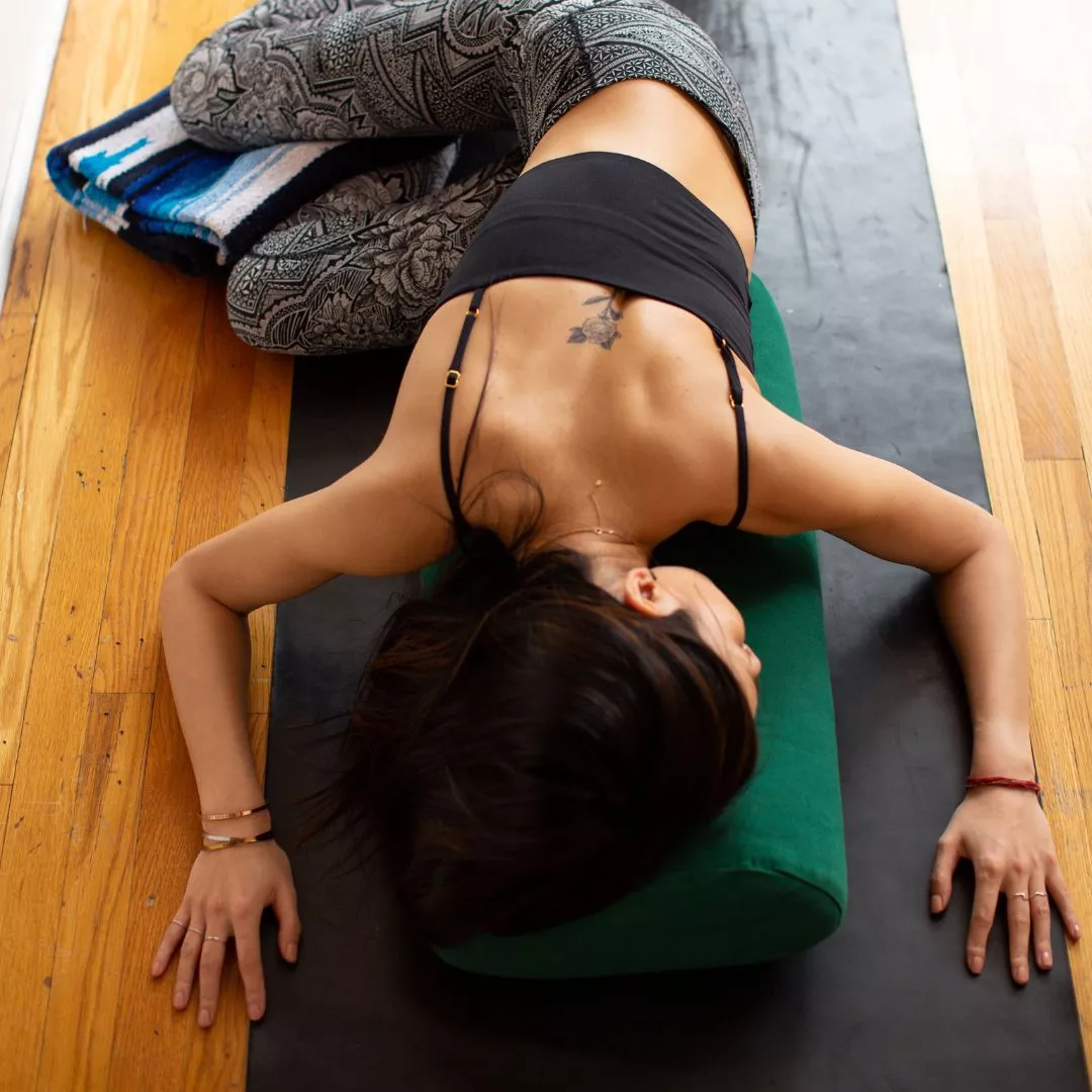 Yoga Stretching: Frau ist in der liegenden Drehung inklusive Hilfsmitteln