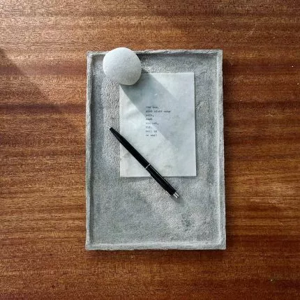 Beton-DIY:Tablett von oben mit Papier, Stein und Stift auf Holztisch