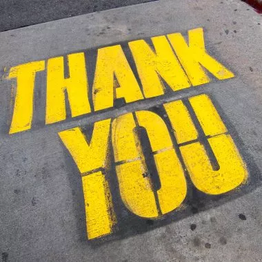 Dankbarkeit: Die Worte "Thank you" auf Asphalt gesprayed.