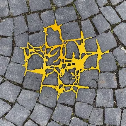 Gelber Kunststoff füllt Risse auf Kopfsteinpflaster, Kintsugi Art