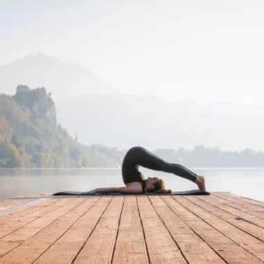 Yin Yoga: Frau ist im Pflug auf einem Steg