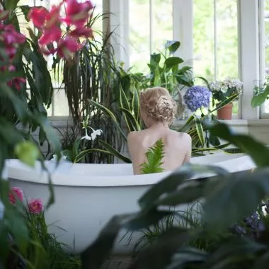 Day-Spa: Frau sitzt in Badewanne, um sie herum Pflanzen