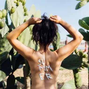 Veganer Sonnenschutz: Auf dem Rücken einer Frau steht mit Sonnencreme geschrieben "Summer"